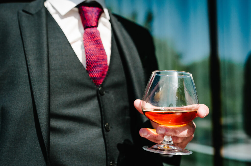 Close up of man hold glass of whiskey, drink alcoholic. Businessman drinking brandy.