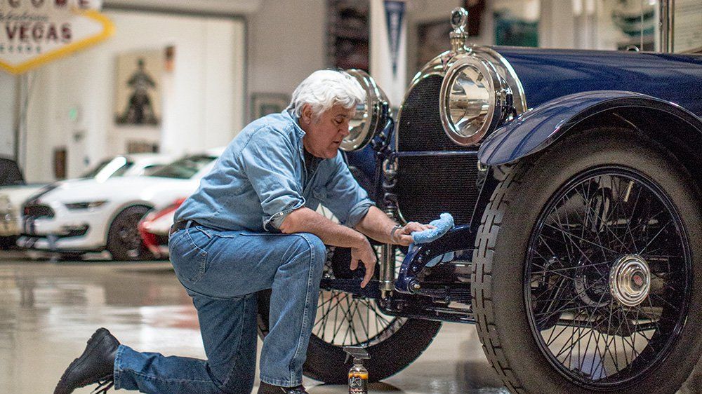 Entertainer Jay Leno detailing one of his many vintage cars